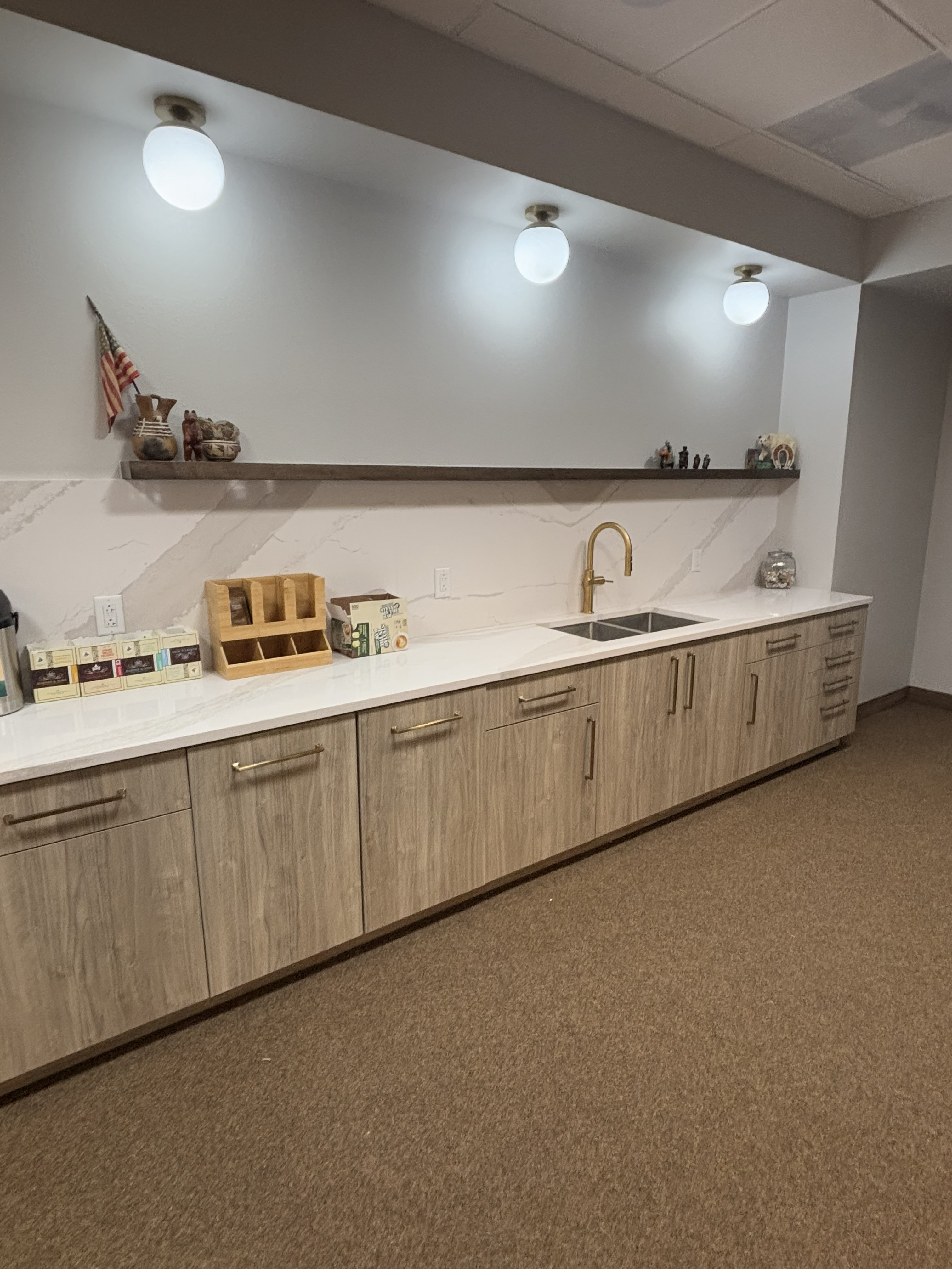 Finished commercial kitchen renovation with modern cabinetry and marble backsplash