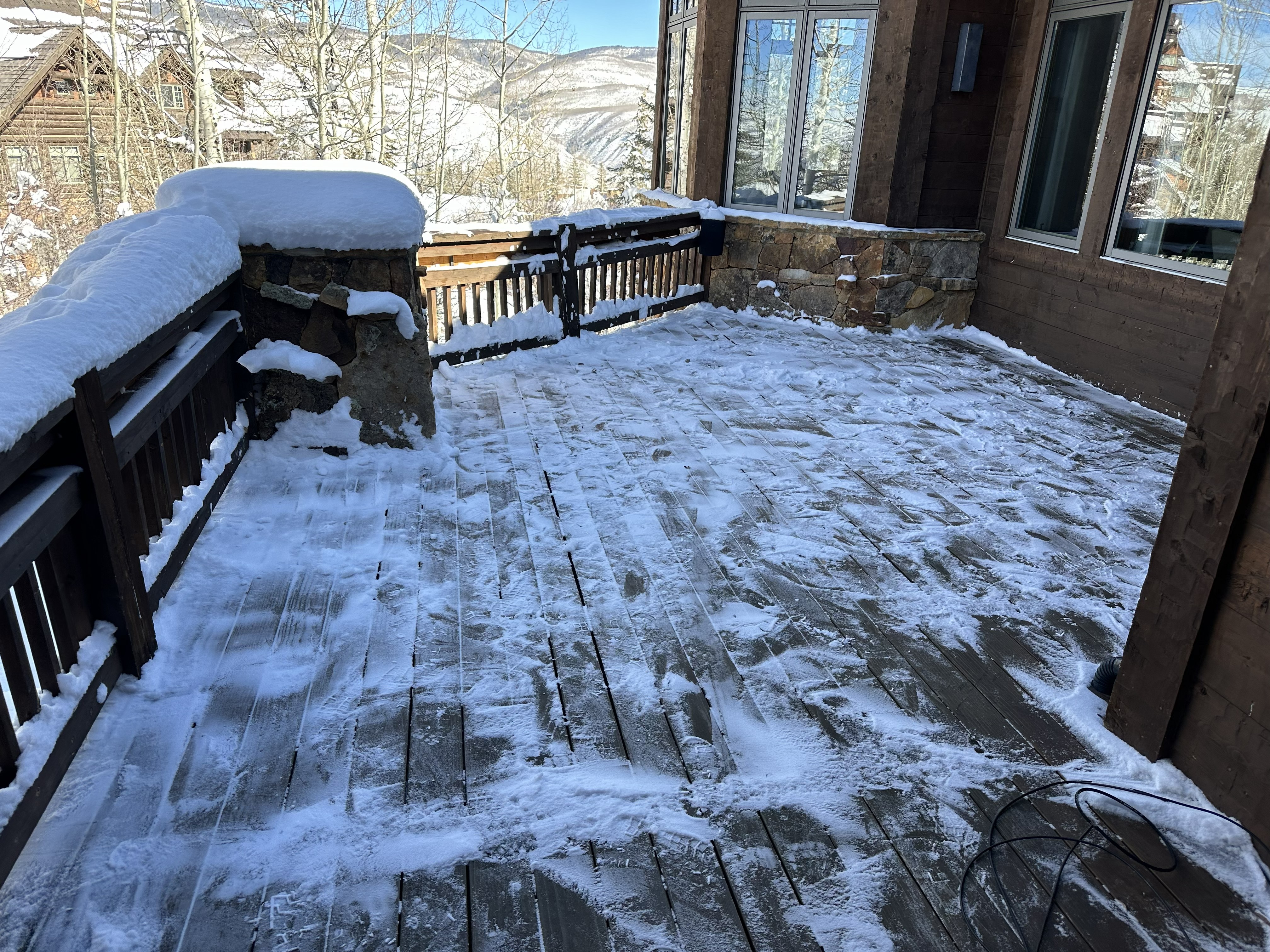 Deck snow clearing with Vail mountain backdrop — Eagle County Colorado