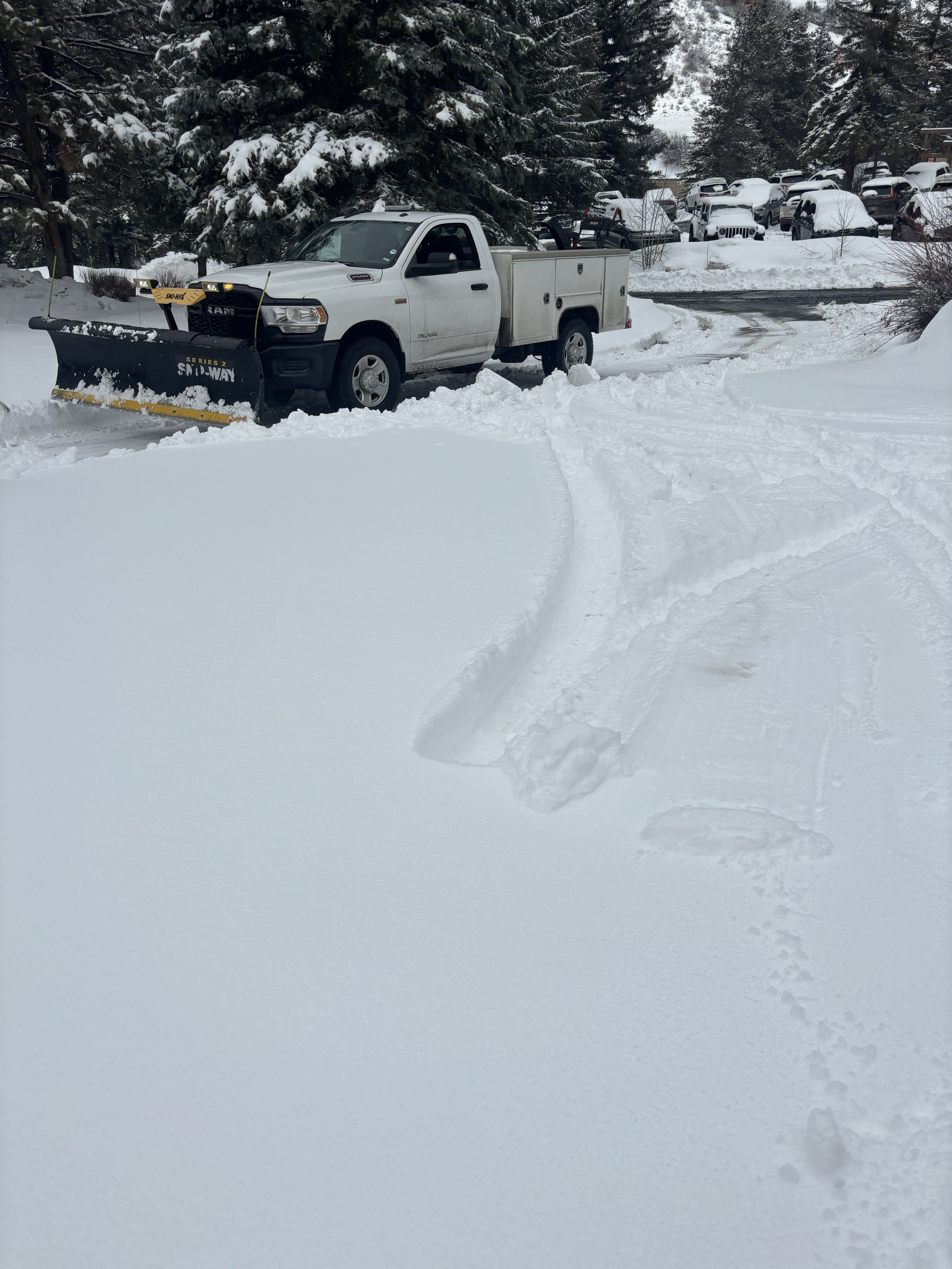 Professional snow plow truck servicing luxury property in heavy snowfall — Vail Valley